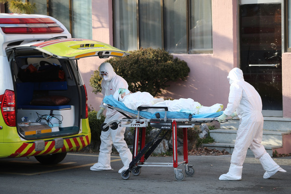 Các nhân viên y tế di chuyển một người nghi nhiễm COVID-19 ở Bệnh viện Daenam ở Cheongdo - Ảnh: REUTERS