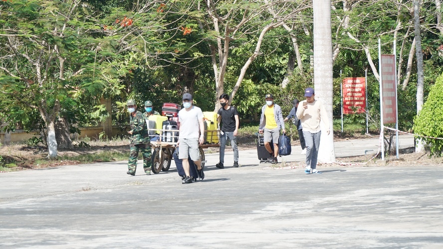 Bộ đội giúp những người sau cách ly đưa hành lý ra xe và thực hiện khử trùng hành lý trước khi ra về.