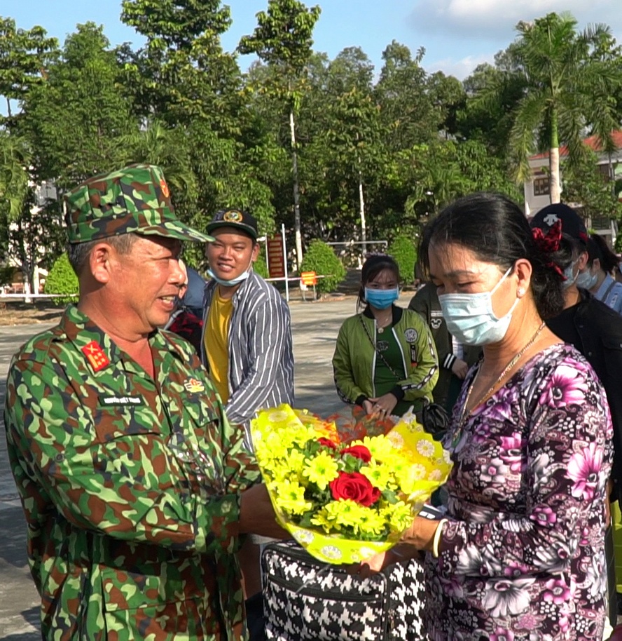 Cùng gửi lời cảm ơn, chúc sức khỏe lẫn nhau. Ảnh: Đại tá Nguyễn Việt Trung- Phó Chính ủy Bộ Chỉ huy Quân sự tỉnh tặng hoa những người hoàn thành kỳ cách ly.