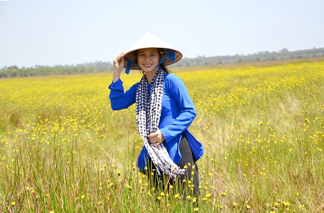 Diễm Trinh - hướng dẫn viên du lịch Vườn Quốc gia Tràm Chim trước cánh đồng hoa hoàng đầu ấn