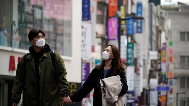 Một cặp đôi đeo khẩu trang khi đi bộ trên con phố vắng ở trung tâm mua sắm, thủ đô Seoul, Han Quốc. Ảnh: Reuters