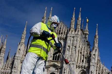 Nhân viên phun thuốc khử trùng nhằm ngăn chặn sự lây lan của dịch COVID-19 tại Milan, Italy, ngày 31/3/2020. Ảnh: AFP/TTXVN