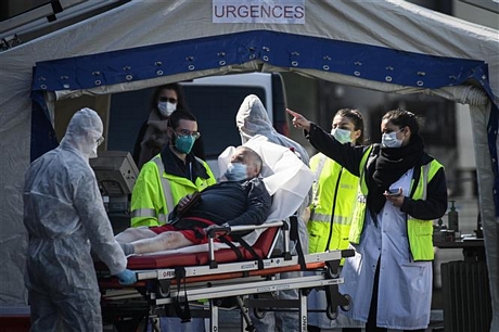 Nhân viên y tế chuyển bệnh nhân nhiễm COVID-19 tới bệnh viện ở ngoại ô Paris, Pháp, ngày 1/4/2020. Ảnh: AFP/TTXVN