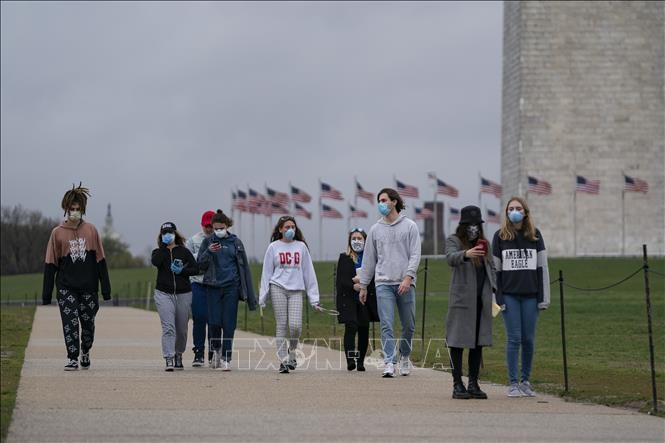 Người dân đeo khẩu trang nhằm ngăn chặn sự lây lan của dịch COVID-19 tại Washington, DC, Mỹ ngày 25/3/2020. Ảnh: AFP/TTXVN
