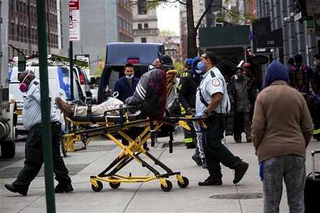 Nhân viên y tế chuyển bệnh nhân COVID-19 lên xe cứu thương tại New York, Mỹ ngày 8/5/2020. Ảnh: THX/ TTXVN