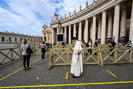 Du khách xếp hàng chờ kiểm tra thân nhiệt trước khi vào Nhà thờ Thánh Peter tại Tòa thánh Vatican ngày 18/5/2020. Ảnh: AFP/TTXVN