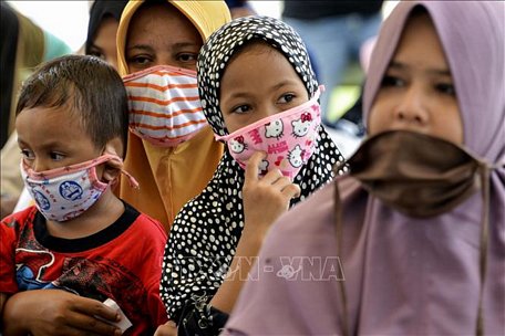 Phụ nữ và trẻ em đeo khẩu trang phòng dịch COVID-19 ở Blang Bintang, tỉnh Aceh, Indonesia ngày 6/5/2020. Ảnh: AFP/TTXVN
