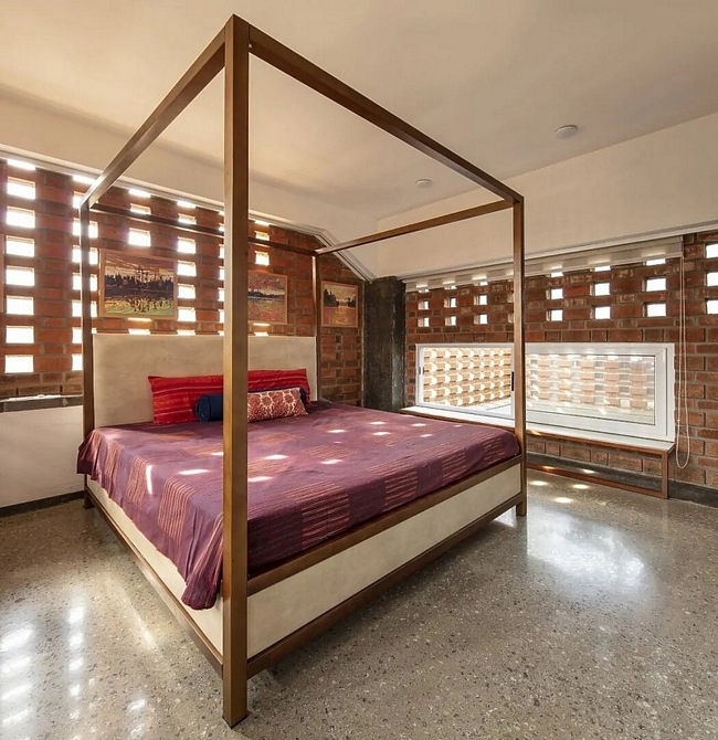 Giường ngủ có khung phù hợp với màu sắc của những bức tường gạch.
