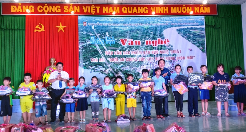 Ông Mai Hữu Ánh (áo xanh) tặng quà cho các em học sinh giỏi.