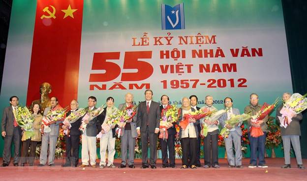 Ông Đinh Thế Huynh, Ủy viên Bộ Chính trị, Bí thư Trung ương Đảng, Trưởng ban Tuyên giáo Trung ương tặng hoa chúc mừng lãnh đạo Hội Nhà văn Việt Nam qua các thời kỳ, tại lễ kỷ niệm 55 năm thành lập (1957-2012). (Ảnh: Thanh Tùng/TTXVN)