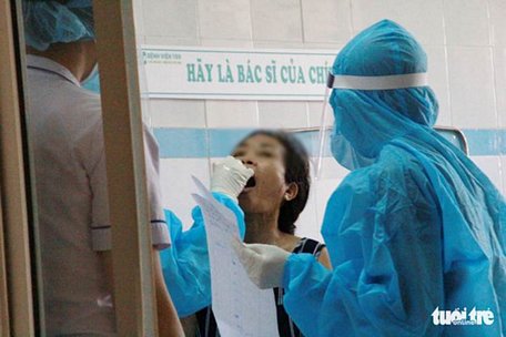 Phết vòm họng lấy bệnh phẩm một bệnh nhân để xét nghiệm virus SARS-CoV-2 tại Bệnh viện 199 Đà Nẵng chiều 28/7 - Ảnh: TRƯỜNG TRUNG