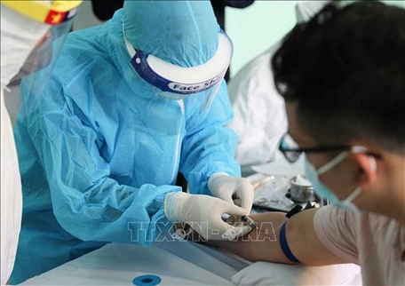  Nhân viên y tế lấy mẫu máu để xét nghiệm nhanh cho người dân tại Trạm Y tế phường Dịch Vọng, quận Cầu Giấy, Hà Nội. Ảnh: Thanh Tùng/TTXVN