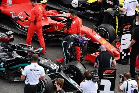 Lewis Hamilton đang kiểm tra lốp xe bị hư hỏng của mình sau chặng đua.