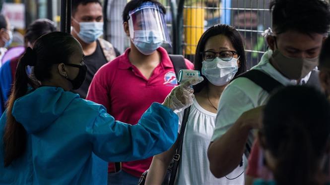 Kiểm tra thân nhiệt của hành khách phòng lây nhiễm COVID-19 tại nhà ga tàu hỏa ở Manila, Philippines, ngày 7/7/2020. Ảnh: AFP/ TTXVN