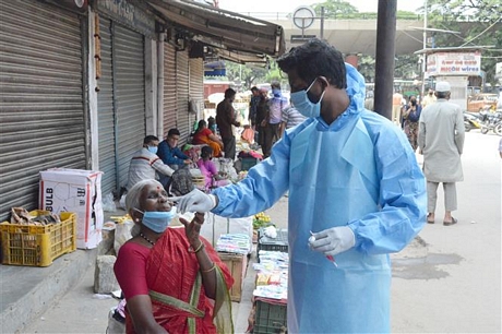 Trong ảnh: Nhân viên y tế lấy mẫu dịch xét nghiệm COVID-19 cho người dân tại một khu chợ ở Bangalore, Ấn Độ ngày 30/8/2020. Ảnh: THX/TTXVN