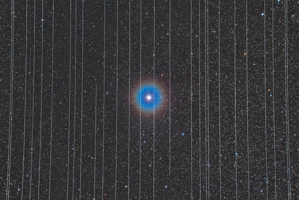 Tác phẩm Nhà tù Công nghệ của Rafael Schmall, người Hungary đoạt giải nhất hạng mục Con người và Không gian. Ngôi sao ở trung tâm của bức ảnh là ngôi sao đôi Albireo, được bao quanh bởi các đường mòn của các vệ tinh chuyển động.  