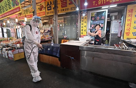 Phun thuốc khử trùng nhằm ngăn chặn sự lây lan của dịch COVID-19 tại một khu chợ ở Seoul, Hàn Quốc ngày 18/8/2020. Ảnh: AFP/TTXVN