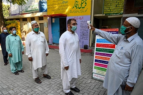 Kiểm tra thân nhiệt phòng lây nhiễm COVID-19 tại Lahore, Pakistan, ngày 12/9/2020. Ảnh: AFP/TTXVN
