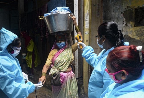  Kiểm tra thân nhiệt phòng lây nhiễm COVID-19 tại Mumbai, Ấn Độ. Ảnh: AFP/TTXVN