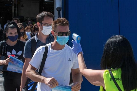 Kiểm tra thân nhiệt cho khách du lịch nhằm ngăn chặn sự lây lan của dịch COVID-19 tại Piraeus, Hy Lạp ngày 20/8/2020. Ảnh: THX/TTXVN