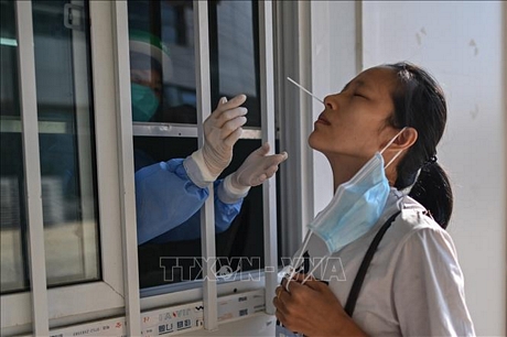 Nhân viên y tế lấy mẫu dịch xét nghiệm COVID-19 cho người dân tại Vũ Hán, tỉnh Hồ Bắc, Trung Quốc ngày 3/9. Ảnh: AFP/TTXVN
