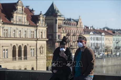 Người dân đeo khẩu trang phòng dịch COVID-19 tại Praha, CH Séc ngày 18/3. Ảnh: AFP/TTXVN