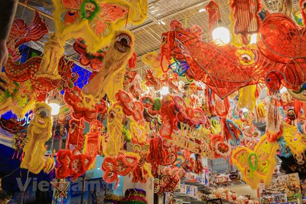 Khu vực được giới trẻ 'check-in' nhiều nhất là khu bán những mặt hàng đồ chơi Trung Thu truyền thống như lồng đèn, mặt nạ, trống, đầu lân… Đối với nhiều bạn trẻ, phố Hàng Mã vẫn rực rỡ, náo nhiệt bất chấp dịch bệnh. (Ảnh: Minh Hiếu/Vietnam+)