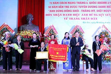 Chủ tịch Quốc hội Nguyễn Thị Kim Ngân trao danh hiệu Anh hùng Lực lượng vũ trang nhân dân cho “Đội quân tóc dài Bến Tre”. Ảnh: Báo Đồng Khởi