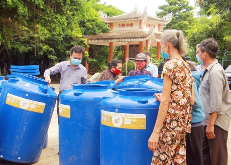 Người dân xã Trung Thành Đông nhận bồn chứa nước.