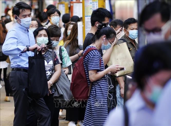 Người dân đeo khẩu trang phòng lây nhiễm COVID-19 khi chờ xe buýt tại Hong Kong, Trung Quốc. Ảnh: THX/TTXVN