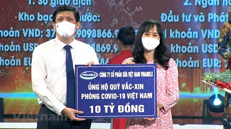 Đại diện Vinamilk trao 10 tỷ đồng đóng góp vào Quỹ Vaccine phòng Covid-19 cho đại diện Bộ Y tế. (Nguồn: Vietnam+)