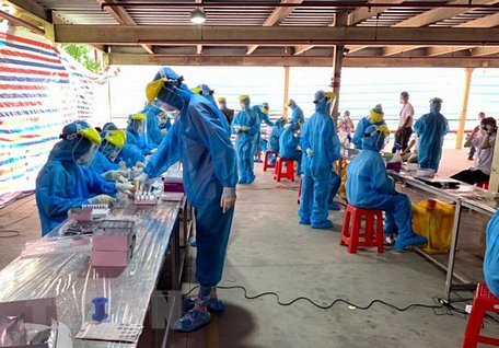 Nhân viên Y tế lấy mẫu test nhanh cho công nhân ở KCN Hòa Phú.