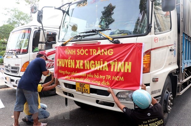Các xe chở hàng hóa thiết yếu tập hợp chuẩn bị xuất phát về Thành phố Hồ Chí Minh. (Ảnh: Trung Hiếu/TTXVN)