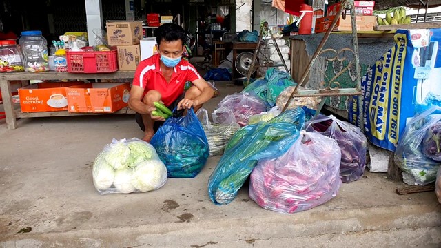  Anh Bùi Hữu L. bán tạp hóa tại Điểm mua bán xã Mỹ Đông, huyện Tháp Mười để rau củ vào bọc gửi tặng người dân trong khu cách ly