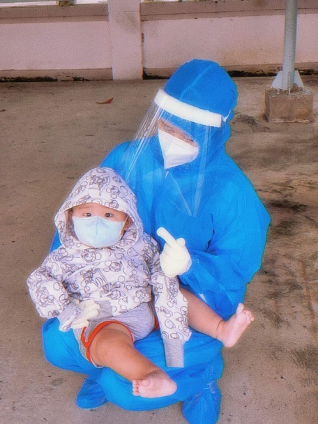 Nhân viên y tế BV Dã chiến số 1 (Khu công nghiệp Hòa Phú) đưa bé nhỏ 10 tháng tuổi xuất viện về cho ba đang là F1 cách ly tập trung tại Trường CĐ Sư phạm.