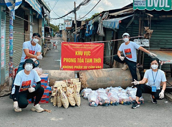 Đinh Hà Uyên Thư (bìa trái, ngồi) mang nhu yếu phẩm tặng người dân khu phong tỏa - Ảnh: Facebook MC Quynh Hoa