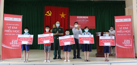 Trung tá Phạm Anh Tuấn– Phó Giám đốc Viettel Vĩnh Long và đại diện Hội Khuyến học huyện Trà Ôn trao học bổng cho các học sinh xã Tân Mỹ.