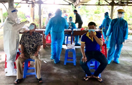 Lực lượng y tế lấy mẫu test nhanh COVID-19 cho người dân tại điểm Trường THPT Nguyễn Thông (Phường 8).