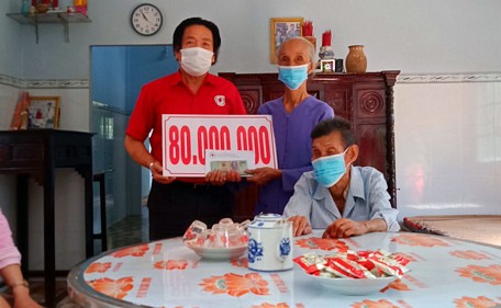 Ông Mai Hữu Ánh thay mặt nhà tài trợ bàn giao 80 triệu đồng cho ông Phạm Phước Long trong lễ bàn giao nhà.