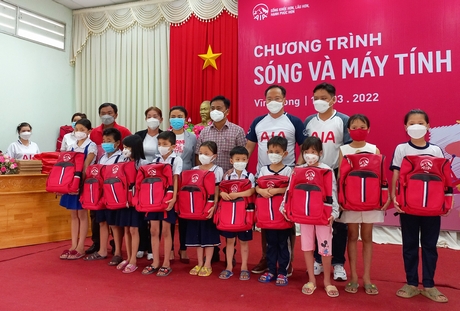 Đại diện AIA Việt Nam tặng quà cho các em học sinh tại huyện Tam Bình.