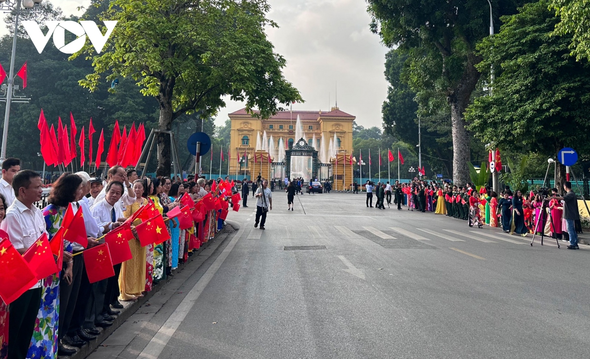 Bên ngoài Phủ Chủ tịch, người dân Hà Nội cầm cờ hai quốc gia đón chào Tổng Bí thư, Chủ tịch Trung Quốc Tập Cận Bình.