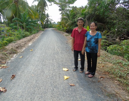 Vợ chồng chị Kim Đồng phấn khởi đi trên con đường khang trang- tại phần đất gia đình mình hiến tặng.