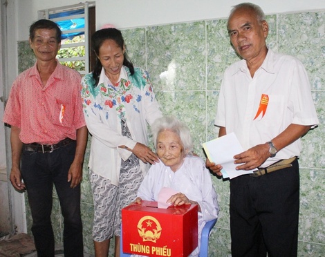 Bà Trần Thị Phấn (87 tuổi, sức khỏe kém, không có khả năng đi lại) được tổ bầu cử đến tận nhà hướng dẫn bà bỏ phiếu.
