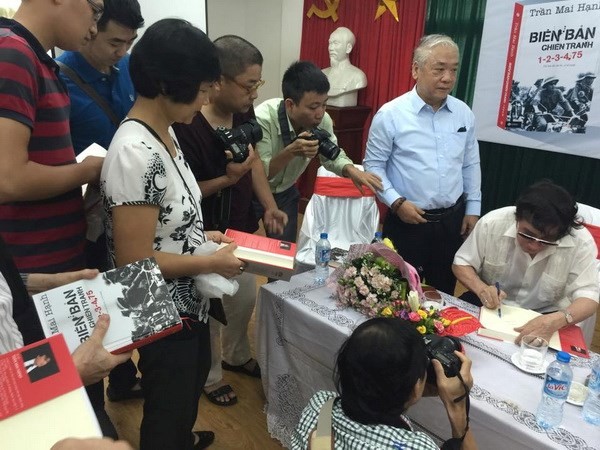 Nhà báo Trần Mai Hạnh ký tặng bạn đọc ( Ảnh: Nguồn TML/Vietnam+)