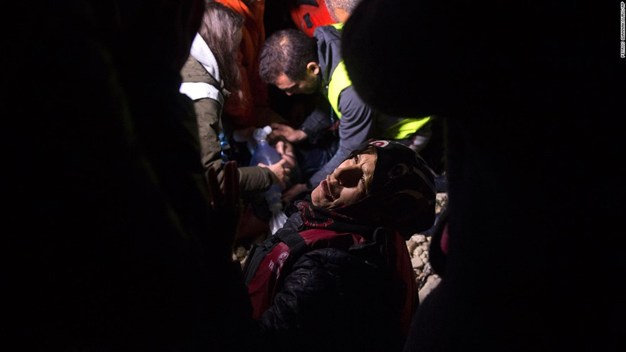 Một người phụ nữ khẩn cầu lực lượng cứu hộ cứu sống chồng bà sau khi ông ngất lịm trên con thuyền nhồi nhét quá nhiều người di cư. (Ảnh: AP)