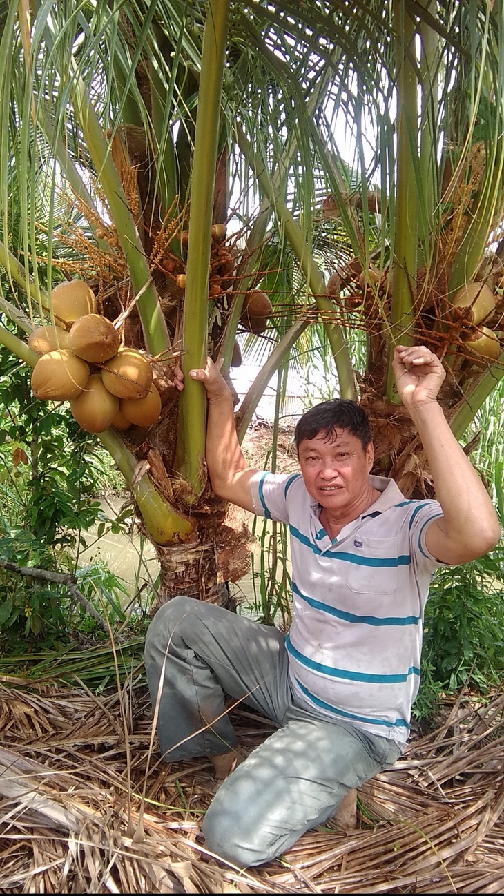 Ông Tám bên cây dừa 2 đọt của mình. 