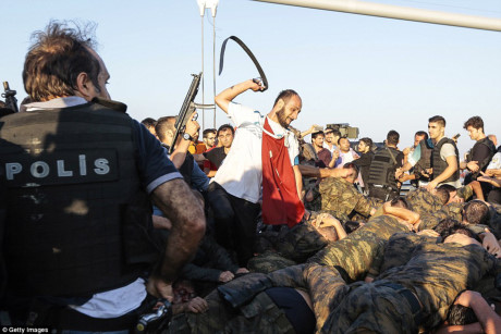 Một người dân Thổ Nhĩ Kỳ dùng thắt lưng đánh vào binh sỹ sau khi họ đầu hàng cảnh sát trên cầu Bosphorus. (Nguồn: DailyMail)