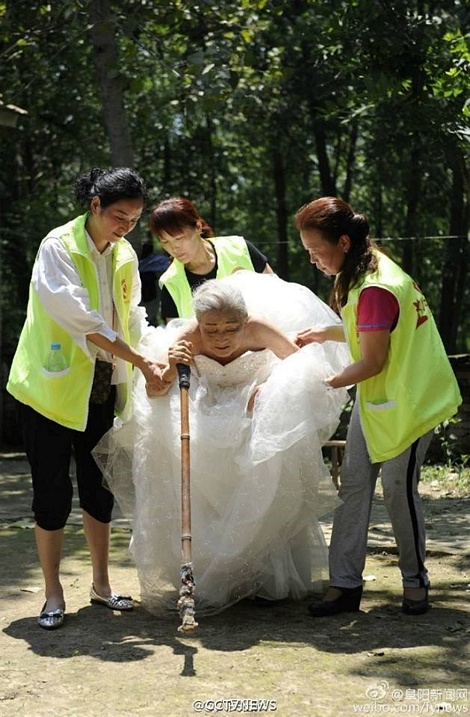 Với sự giúp đỡ của các tình nguyện viên, đôi vợ chồng già lại được mặc váy cưới lần thứ 2 để chụp tấm ảnh cưới đầu tiên của đời mình. (Nguồn: CCTVNews)