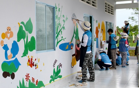 Các tình nguyện viên hăng say vẽ tranh lên các phòng học mẫu giáo.