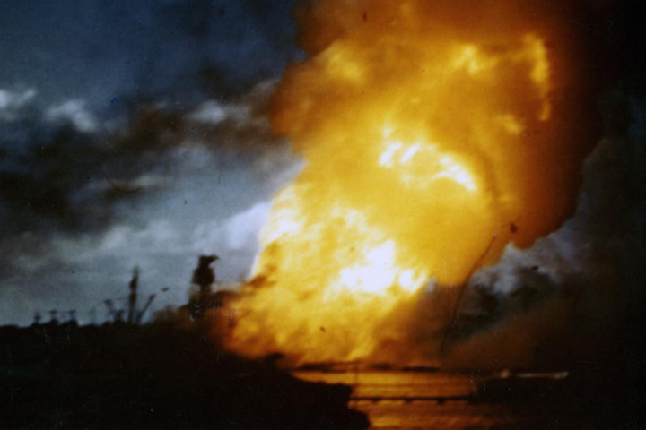 Chiến hạm USS Arizona bốc cháy sau khi buồng đạn của nó phát nổ. Ảnh tĩnh này trích xuất từ một đoạn phim màu quay từ boong tàu USS Solace.